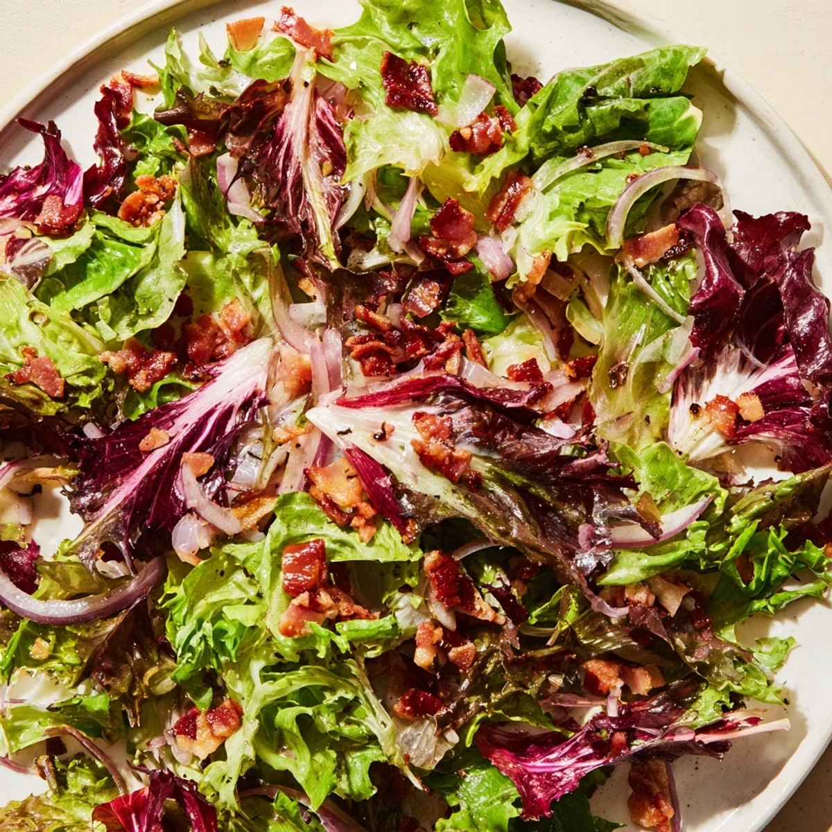 Vibrant photo of Bitter Greens Salad with Warm Bacon Dressing, a savory starter ready to be served.