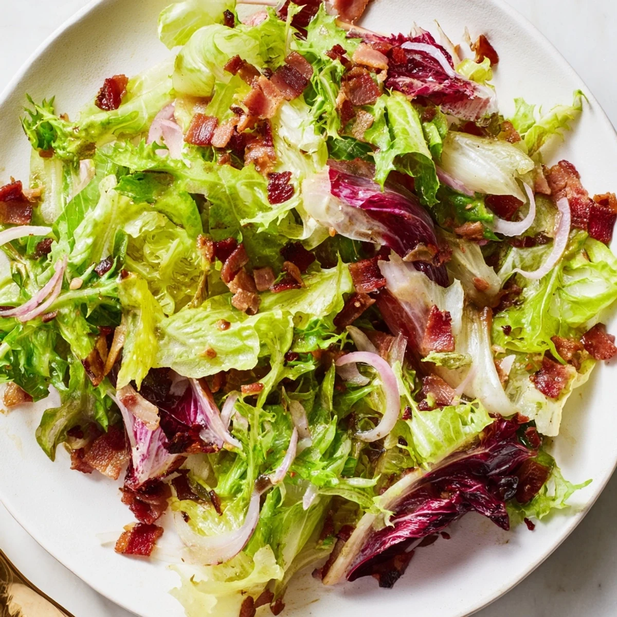 Close-up of freshly tossed Bitter Greens Salad with Warm Bacon Dressing, a delightful, gluten-free dish.
