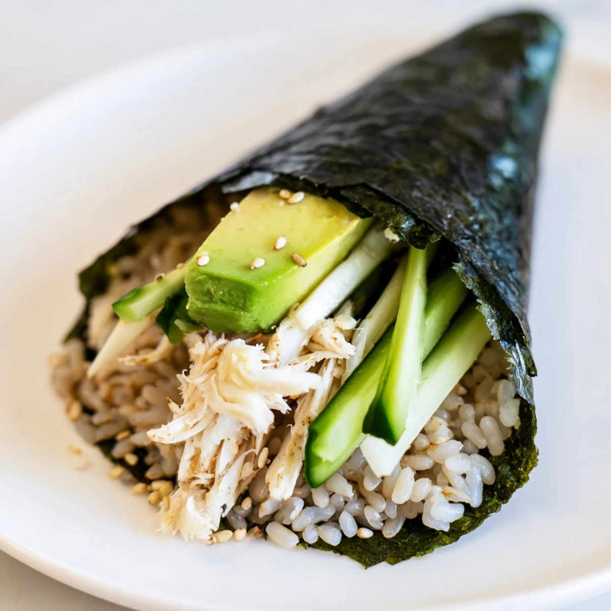 Vibrant sushi rice hand rolls filled with creamy avocado, crisp cucumber, and sweet crab, served with pickled ginger and wasabi.