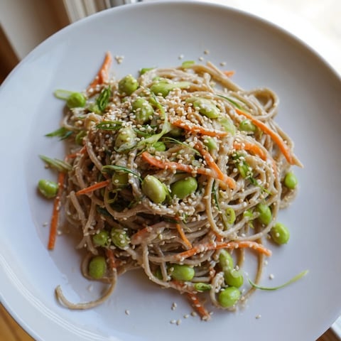 A vibrant bowl of Asian Sesame Noodle Salad with colorful vegetables and a creamy sauce.