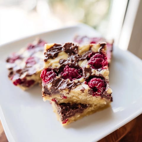 A close-up of freshly baked Decadent White Chocolate and Raspberry Blondies, perfect for sharing and enjoying.