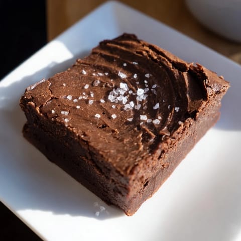 Warm, rich homemade dark chocolate and sea salt brownies ready to serve after baking in the oven.