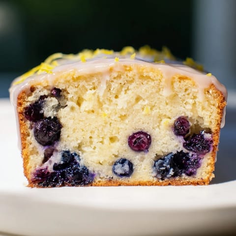 A freshly baked Lemon Blueberry Yogurt Loaf, showing off juicy blueberries in every delightful slice.
