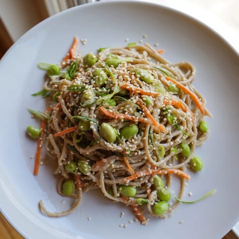 A vibrant bowl of Asian Sesame Noodle Salad with colorful vegetables and a creamy sauce.