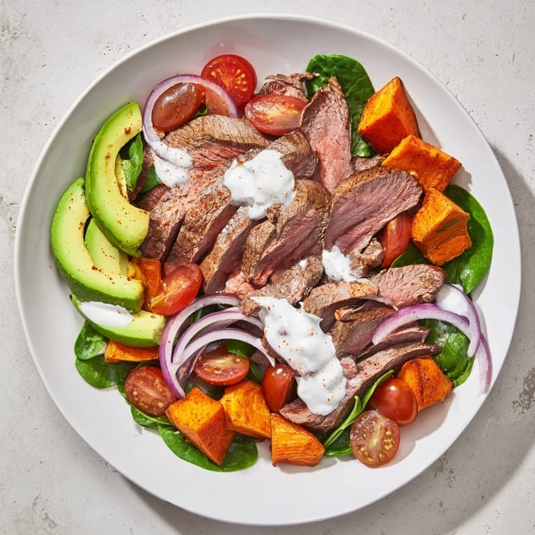 This satisfying Beef Avocado Sweet Potato Bowl features seared beef with fresh toppings and a tangy yogurt dressing.